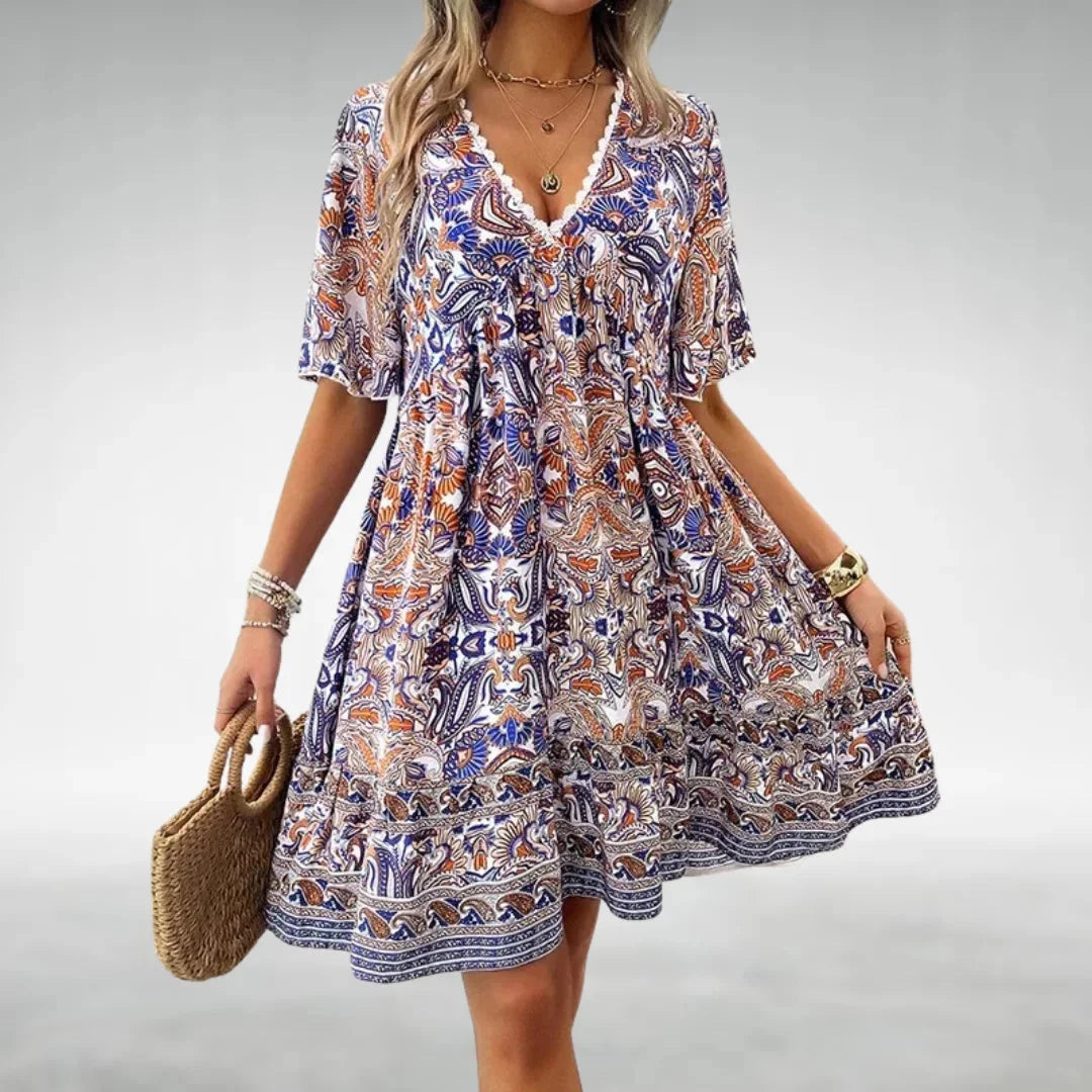 Blue bohemian mini dress with drawstring neckline in flowing fabric, perfect for a casual chic look.