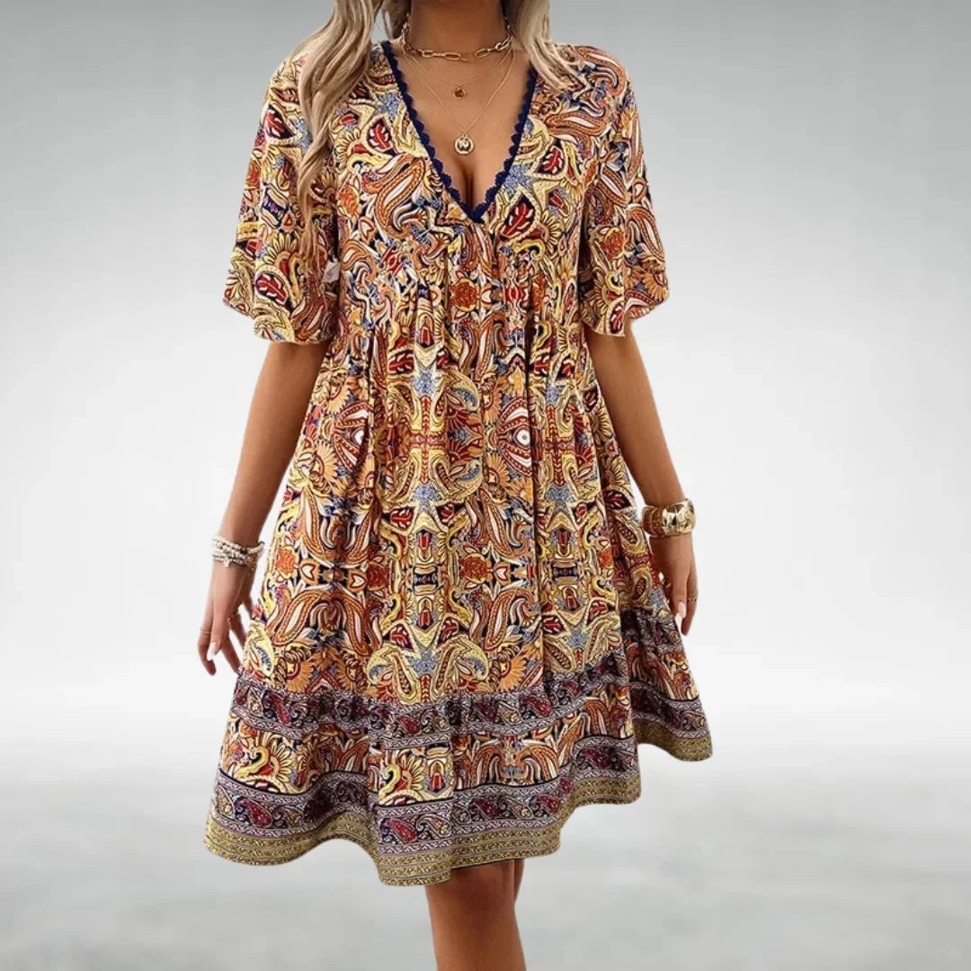 Yellow bohemian mini dress with drawstring neckline in soft cotton blend. Flowy silhouette and intricate embroidered details.