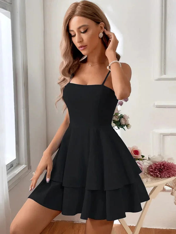 Black tiered mini dress with adjustable straps. Made of soft, flowing fabric. Perfect for casual or dressy occasions.