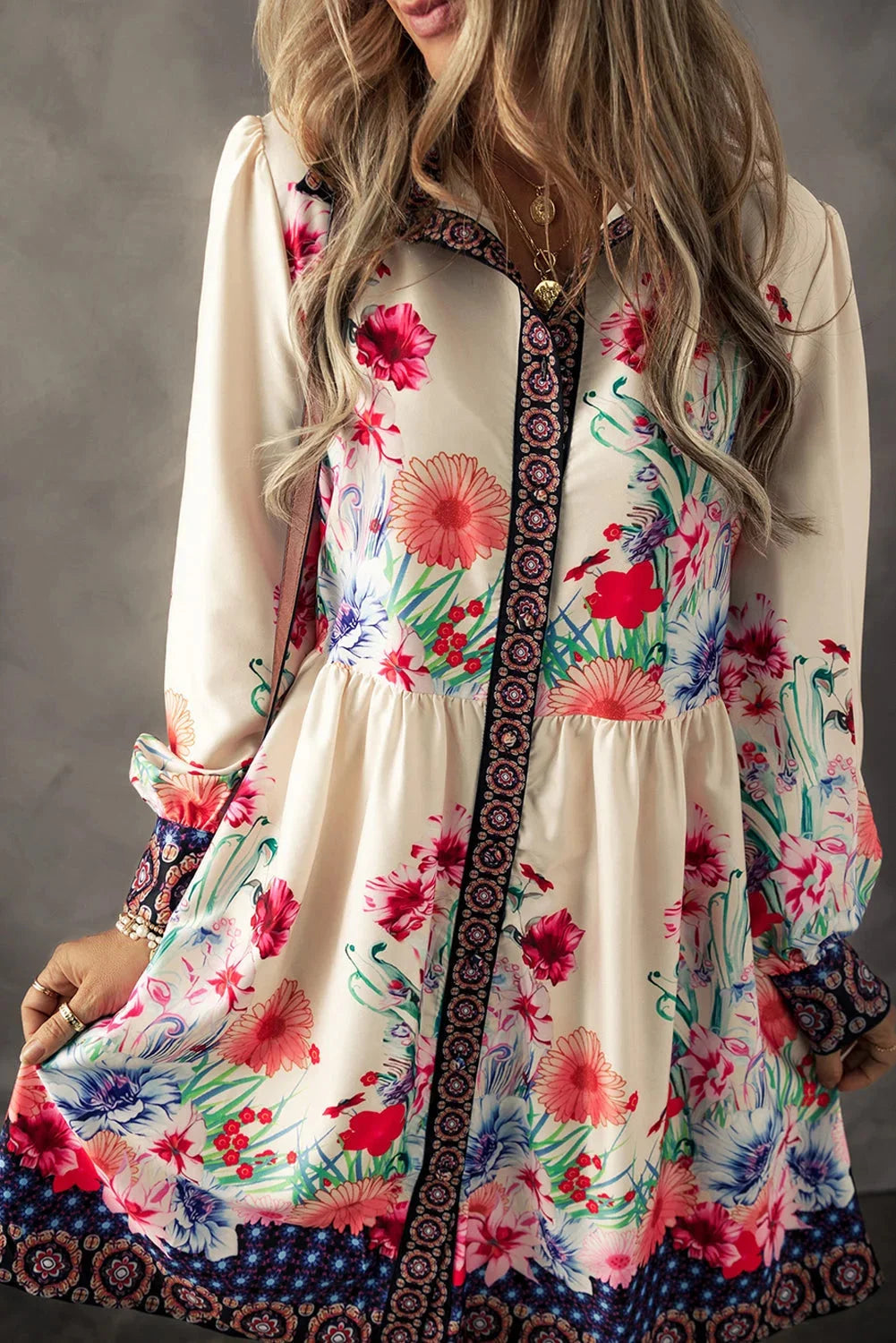 Beige mini dress with colorful floral print, flowy silhouette, and lightweight fabric.