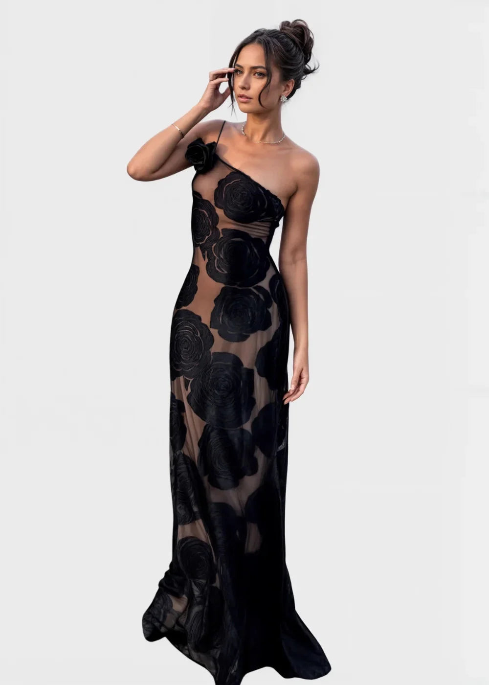 Sheer one-shoulder maxi dress with black roses design. Feminine and elegant, perfect for special occasions.