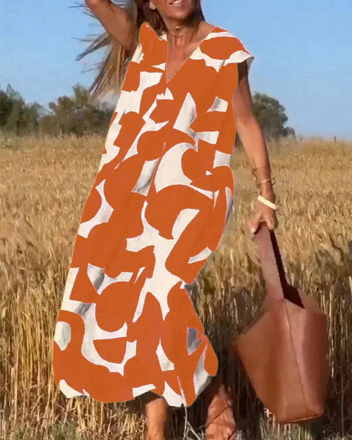 Vibrant orange flowy V-neck maxi dress with bold patterns, made from soft and breathable fabric. Perfect for a casual yet…