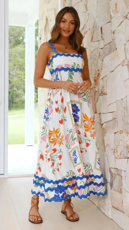 "White and blue sleeveless maxi dress with wave trim design, made with comfortable and lightweight fabric."