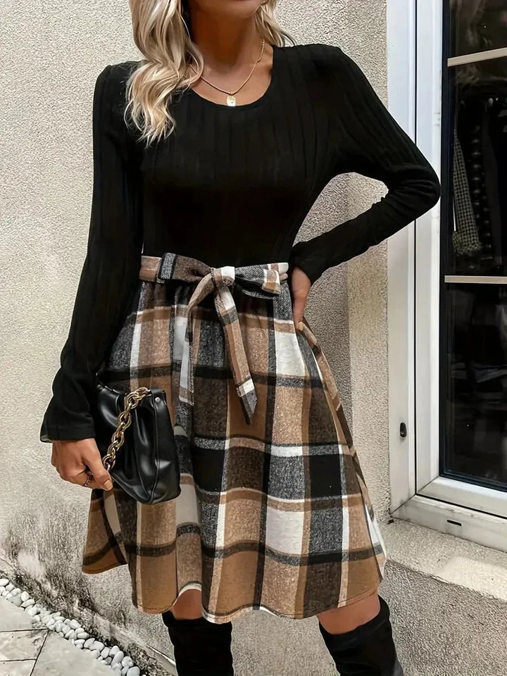 "Black fitted top with A-line check skirt, made of premium quality material, perfect for a fashionable and versatile look."