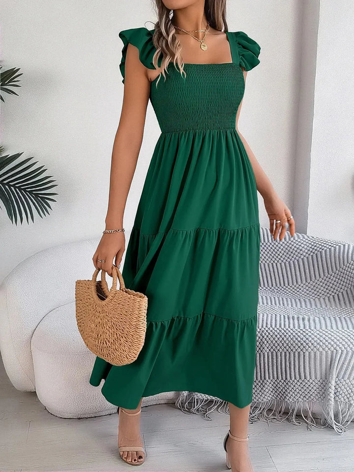 Smocked green midi dress with tiered ruffles, made from lightweight and flowy fabric, perfect for a stylish and feminine…