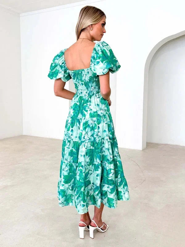 Flowing floral tiered summer dress with vibrant colors and lightweight fabric ideal for warm days.