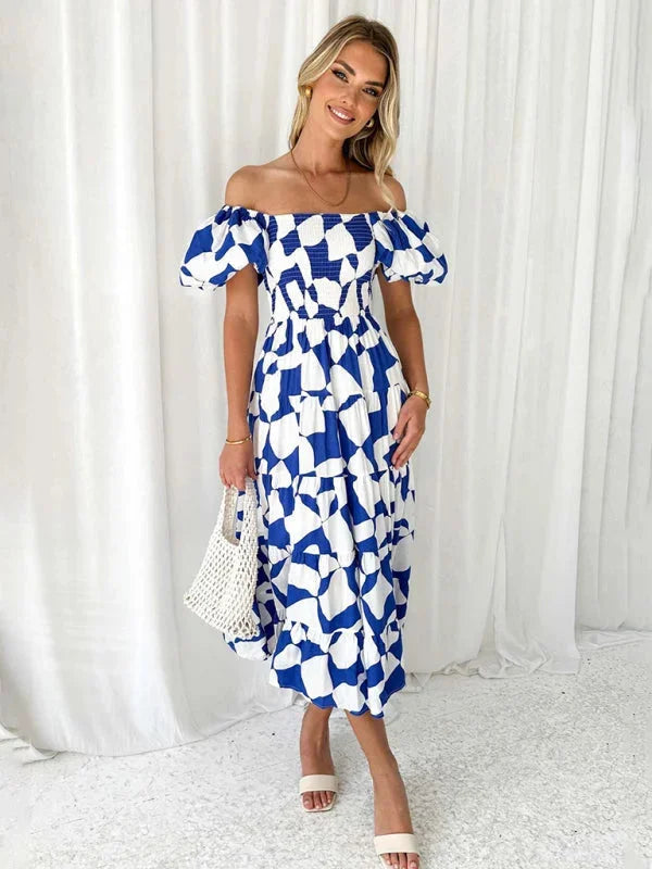 "Blue and white floral tiered dress with flowing design, perfect for summer days."