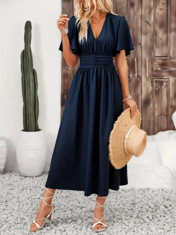 "Navy blue V-neck sundress with ruffled sleeves, made of airy cotton blend, perfect for summer days."