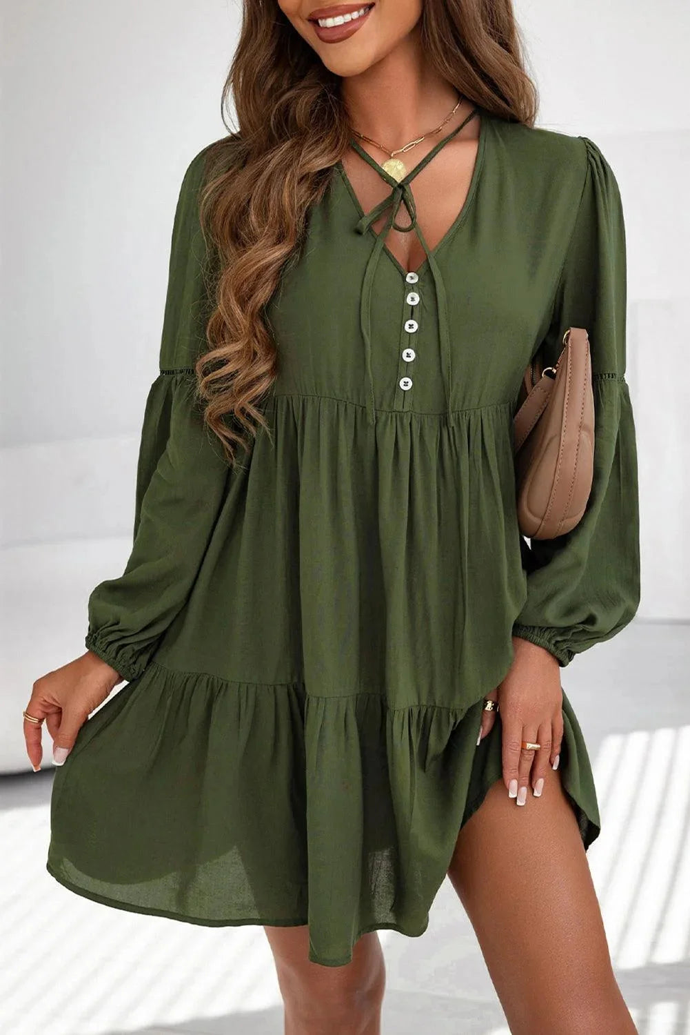 Green tiered mini dress with lace-up front, made of soft cotton blend. Perfect for a casual yet elegant look.