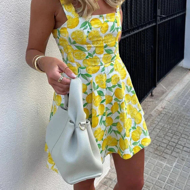 Sleeveless yellow mini dress with lemon print, ideal for summer outings. Soft cotton blend fabric with a vibrant fruit…