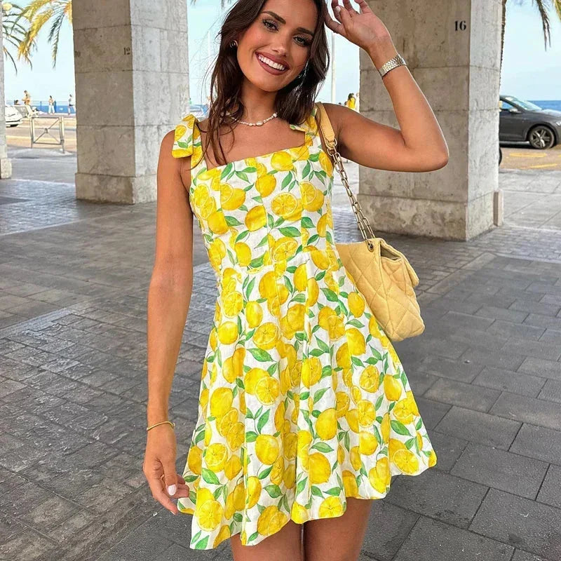 "Sleeveless yellow mini dress with lemon print, perfect for summer. Made from lightweight and breathable fabric."