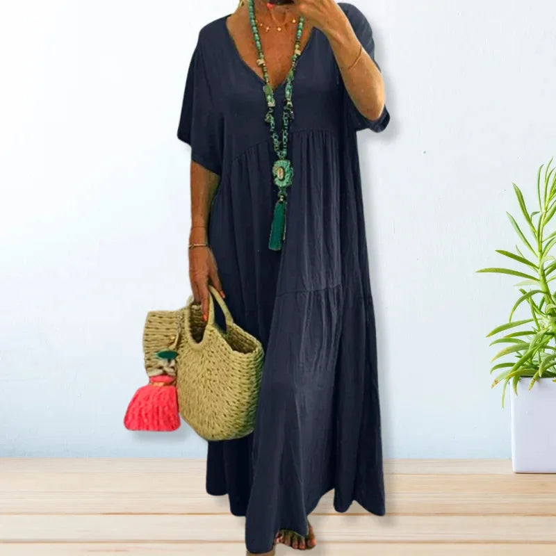 Dark blue V-neck maxi dress for summer made of lightweight fabric. Features flowy design perfect for warm weather styling.