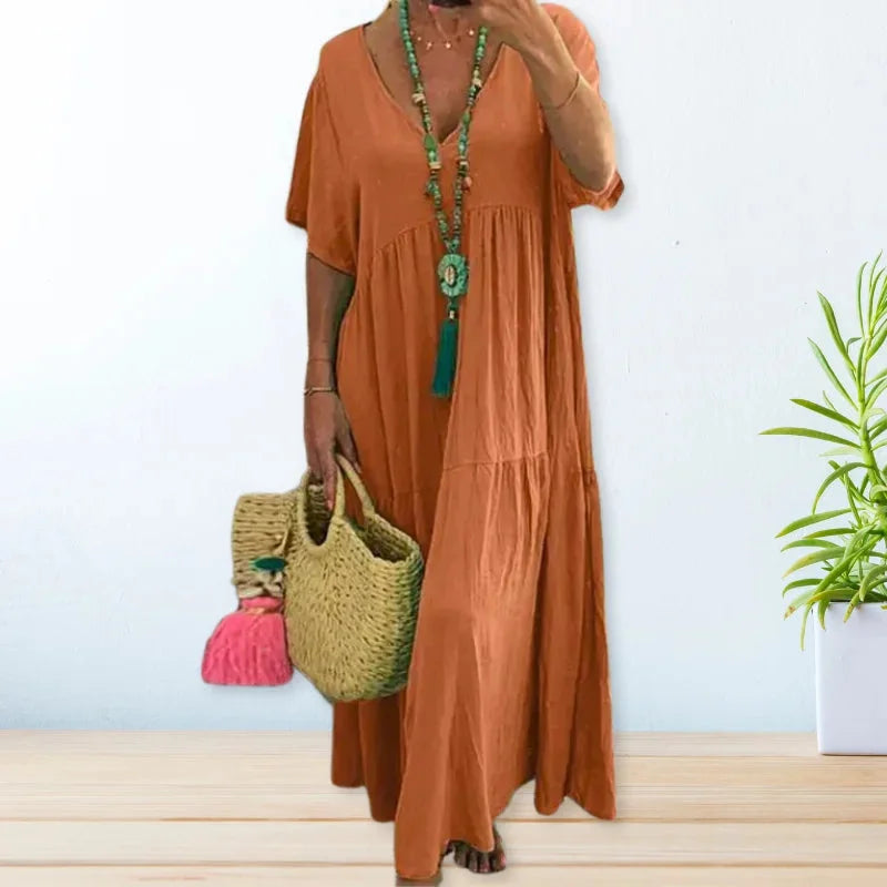 Orange V-neck maxi dress in lightweight fabric perfect for summer. Flowy and breathable design for a stylish and comfortable…