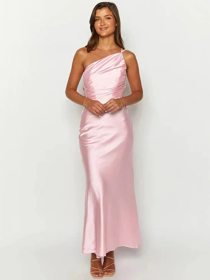 Pink satin maxi dress with a one-shoulder design. Flowing and elegant, perfect for special occasions.