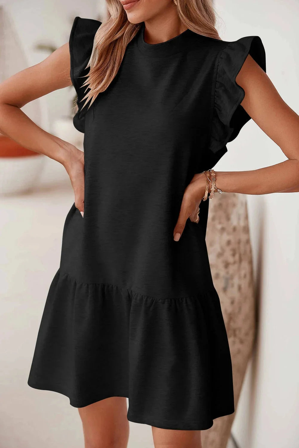 Black mini dress with ruffle detail sleeves made from lightweight cotton blend fabric, perfect for a casual yet stylish look.