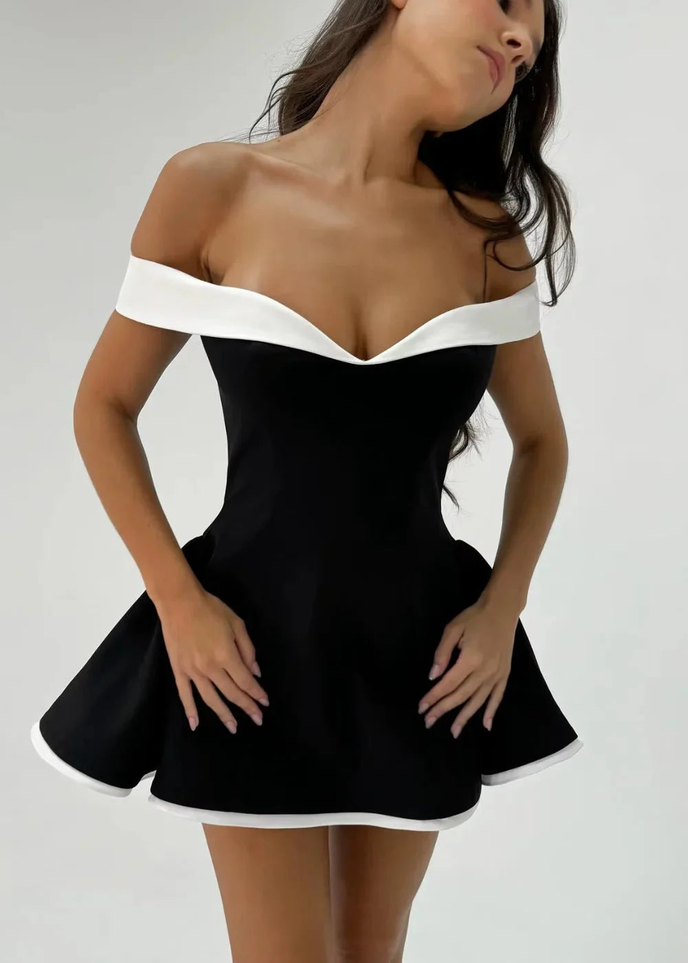 Black off-shoulder dress with white trim, featuring a flared skirt. Made of high-quality stretch fabric with a flattering…