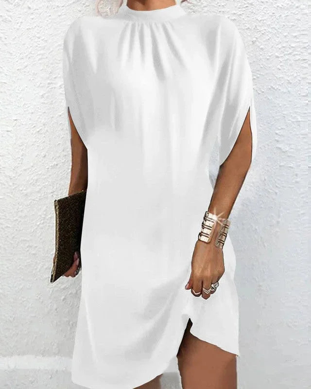 "White mini dress with batwing sleeves, pleated neckline. Soft fabric, loose fit, perfect for any occasion."