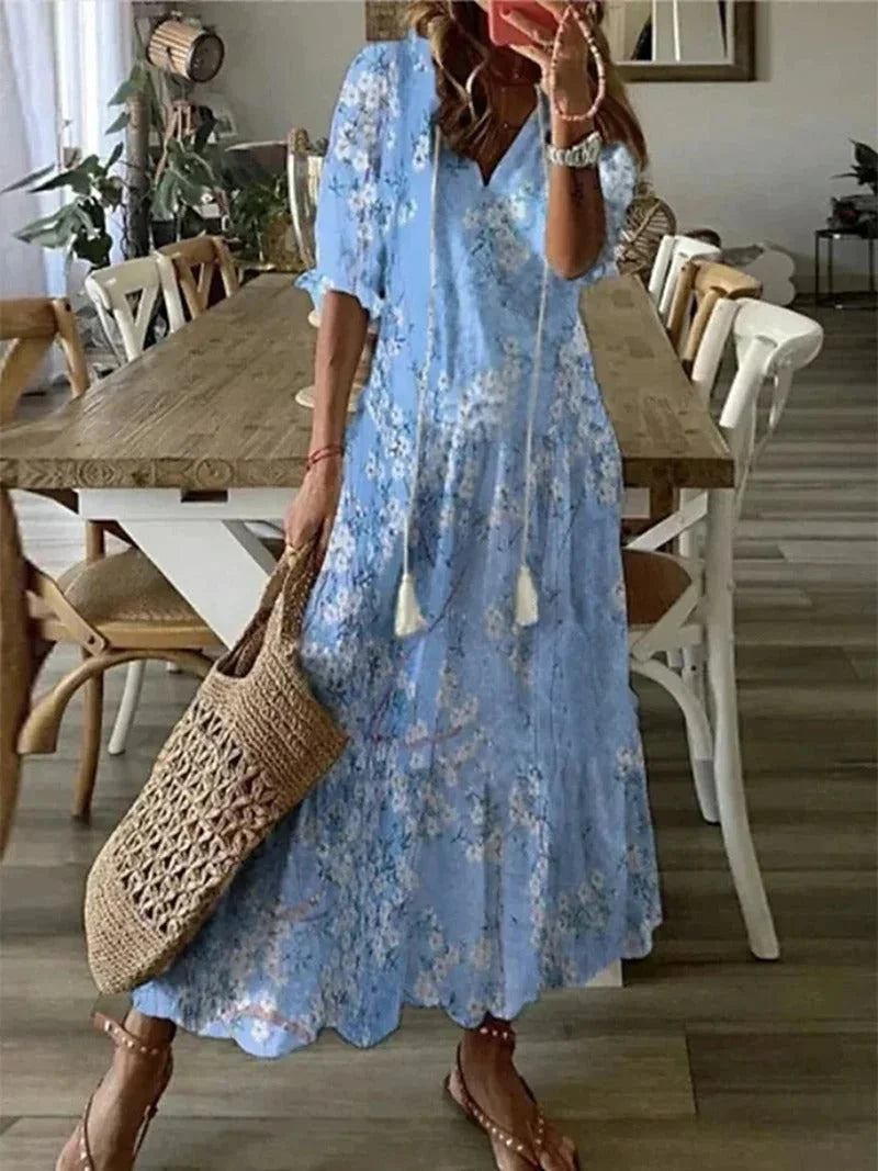 Light blue elbow sleeve floral maxi dress with a relaxed fit made of soft cotton blend fabric, featuring a subtle floral…