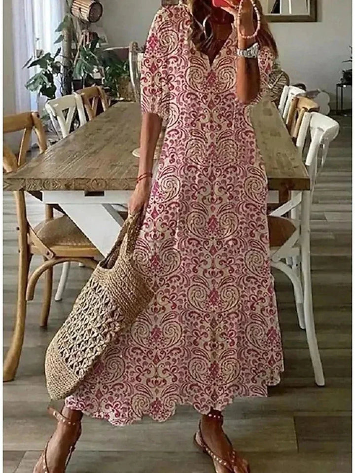 Pink floral maxi dress with elbow sleeves. Soft and flowy material with a flattering fit. Perfect for a casual yet chic look.