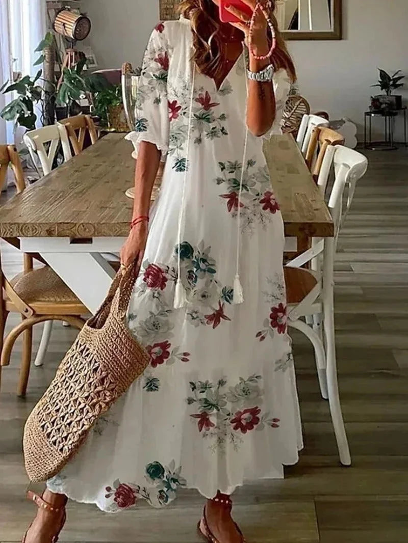 White floral maxi dress with elbow-length sleeves, made from a lightweight and breathable material. Perfect for a summery…