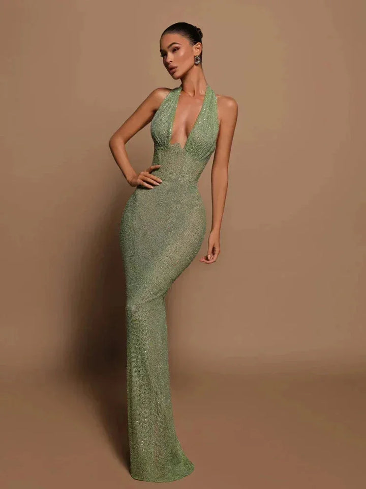 "Green halterneck evening dress featuring shimmering fabric, perfect for formal events."