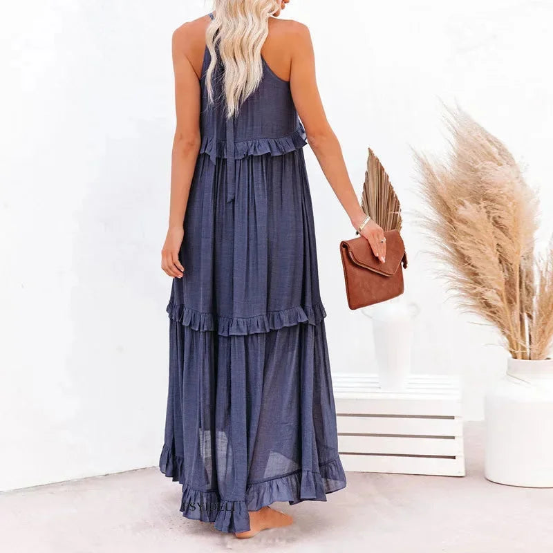 Sleeveless tiered maxi dress in a soft flowy fabric with a subtle floral pattern, perfect for sunny days or casual outings.