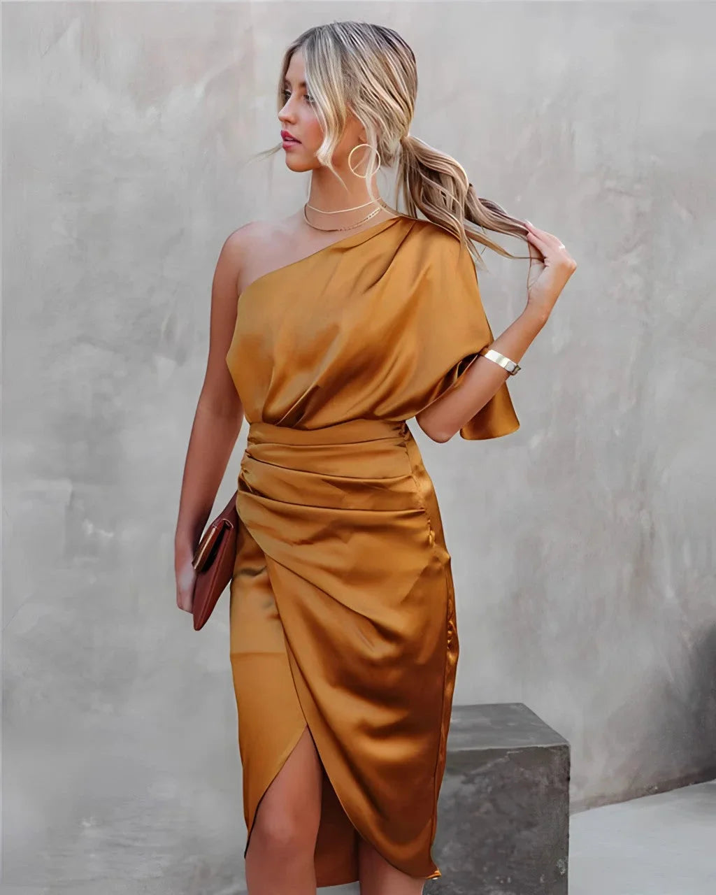 Orange draped midi dress made from soft jersey fabric with a stylish halo neckline, perfect for a chic and sophisticated…