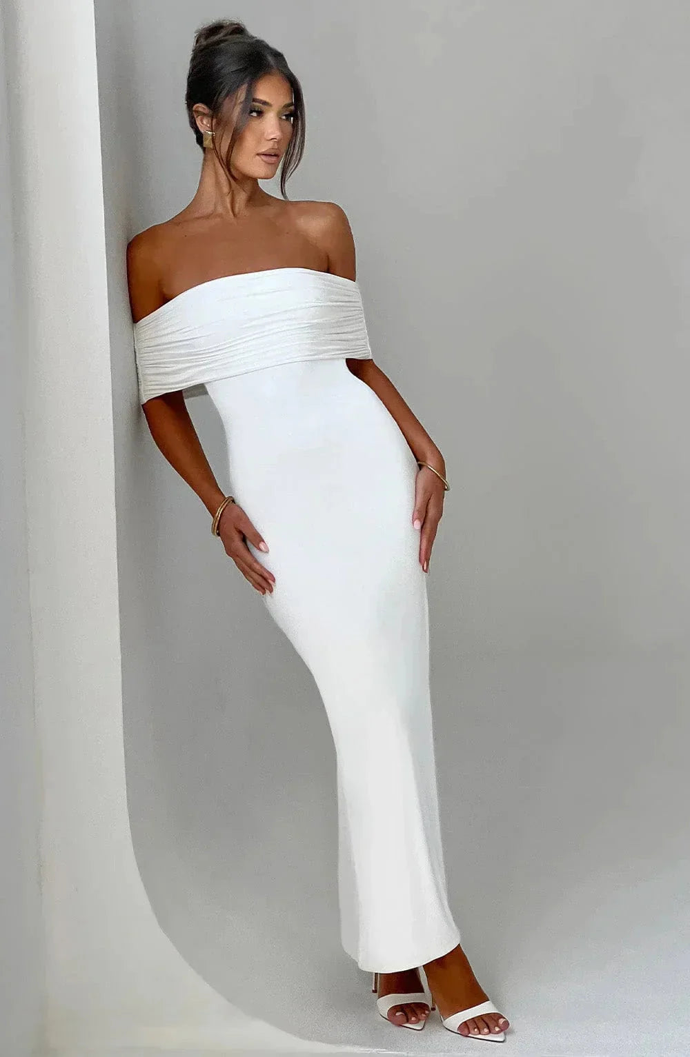 White off-shoulder dress with ruched details, body-hugging fit, perfect for special occasions.