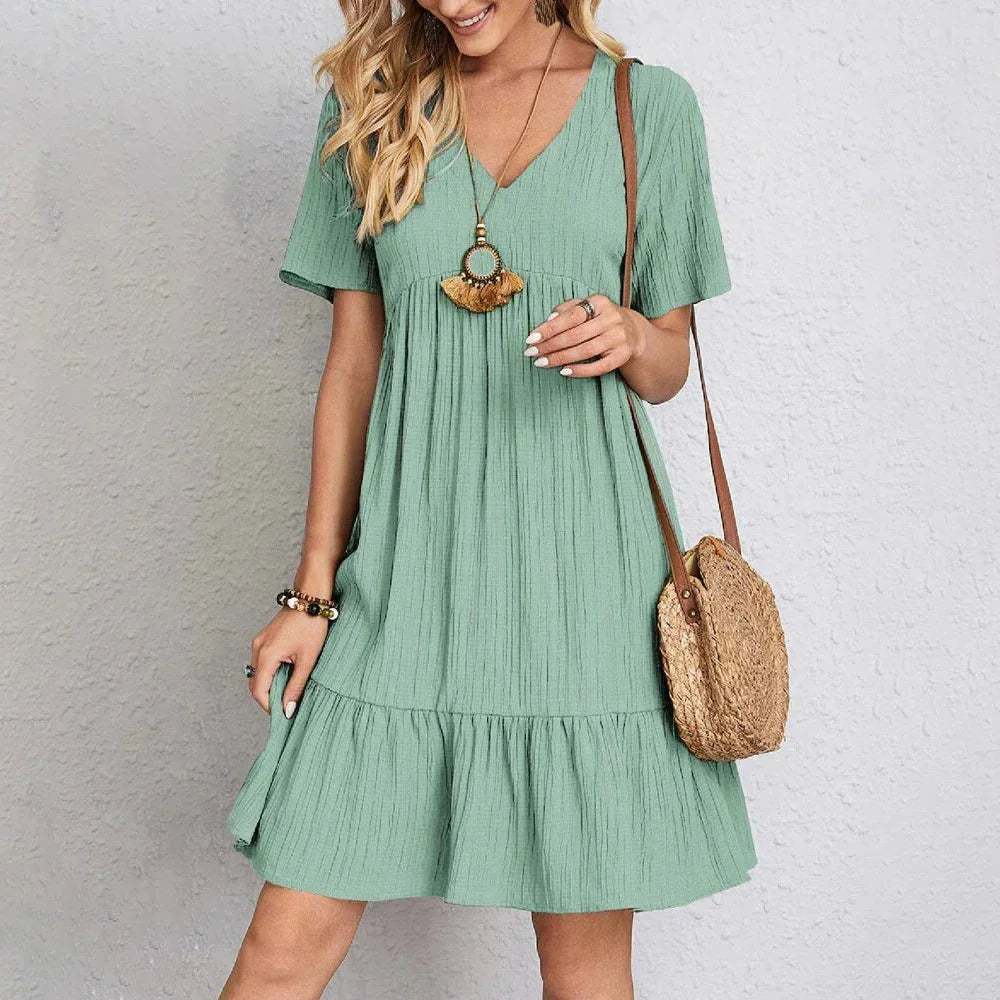 Light green V-neck mini dress with ruffle hem, made of breathable polyester fabric. Perfect for a casual day out or a summer…