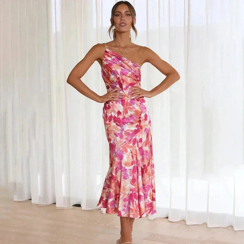 Pink floral dress with asymmetrical design, fitted silhouette, and eye-catching style.