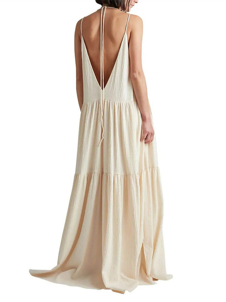 Cream V-neck maxi dress with flowing tiered skirt, made of lightweight fabric, perfect for a breezy and elegant look.