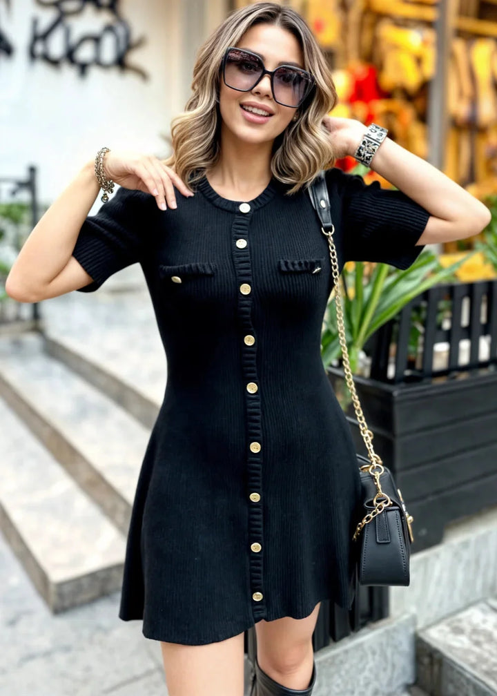 Ribbed knit mini dress in black with button details. Knee-length, sleeveless design perfect for casual outings or summer…