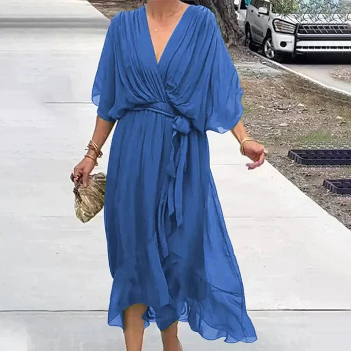 Blue V-neck midi wrap dress with tie waist in a soft, flowy fabric. Elegant design perfect for everyday wear or special…