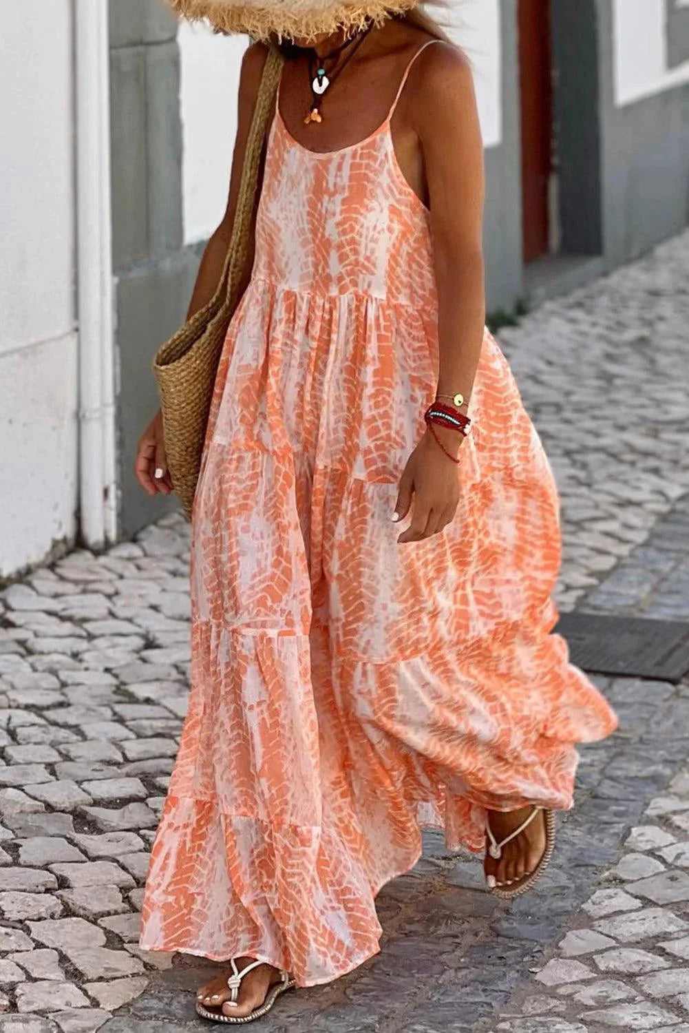 "Kahlani maxi dress in peach with layered skirt, perfect for summer. Flowy fabric with a vibrant orange hue."