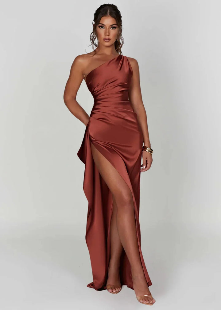 Rust satin one-shoulder dress with slit showcasing elegant draping and an asymmetrical silhouette for a sophisticated look.