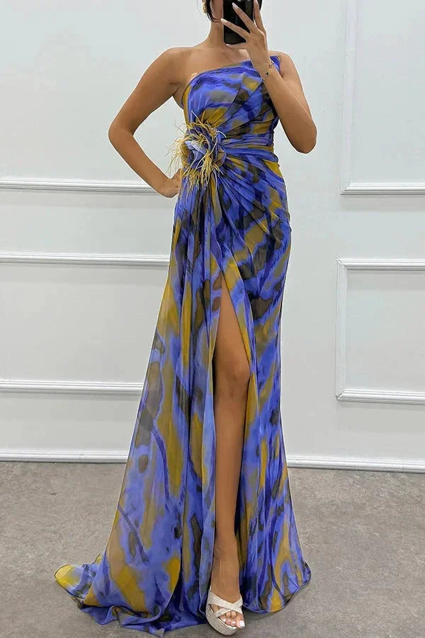 "Karla maxi dress featuring bold floral print, side slit, and flowing silhouette in a lightweight fabric."