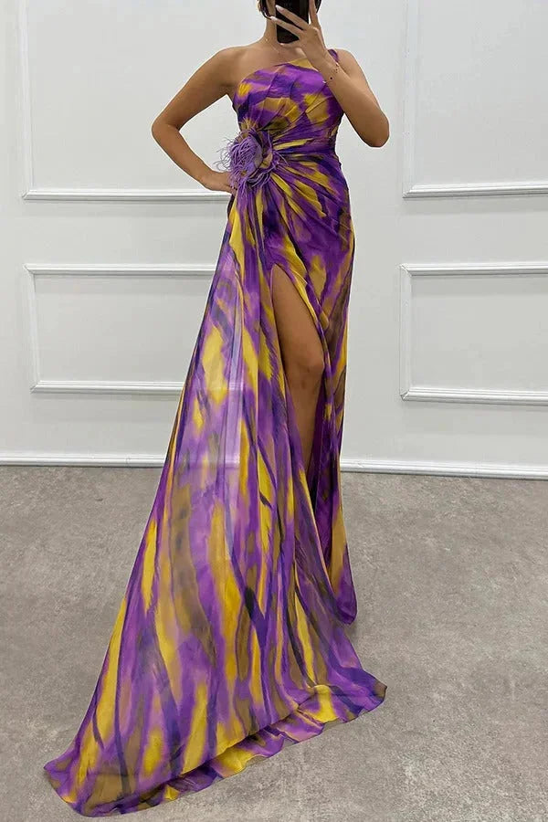 Purple floral maxi dress with side slit, perfect for a summer day. Features a bold floral print and flowy design.