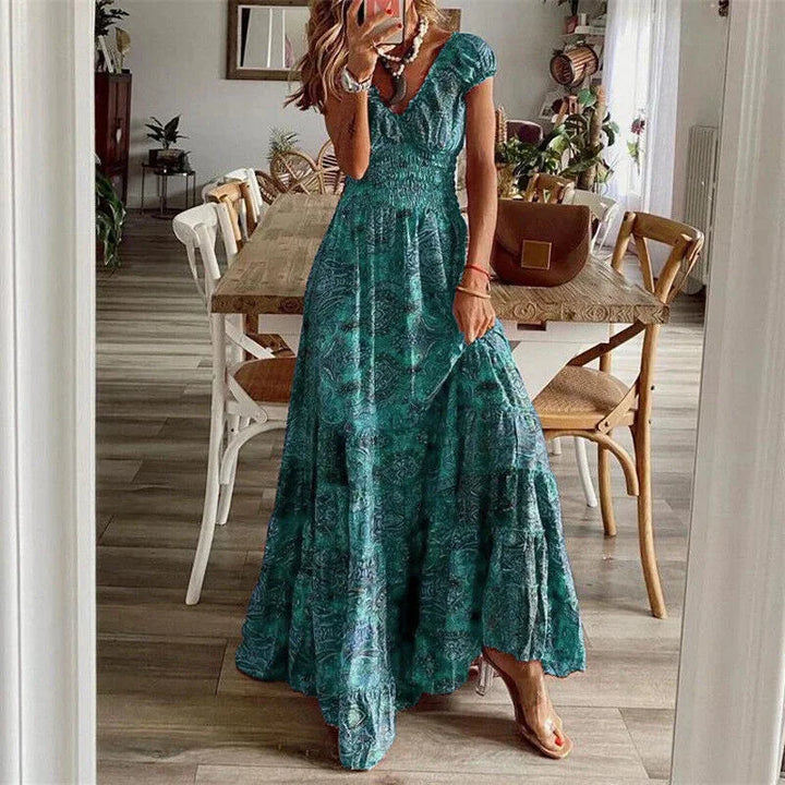 Green tiered boho dress with sleeves, made of flowy fabric. Detailed with intricate patterns, perfect for a casual chic look.