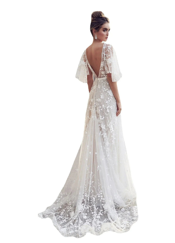 Ivory maxi dress with flutter sleeves, intricate embroidery, perfect for special occasions.