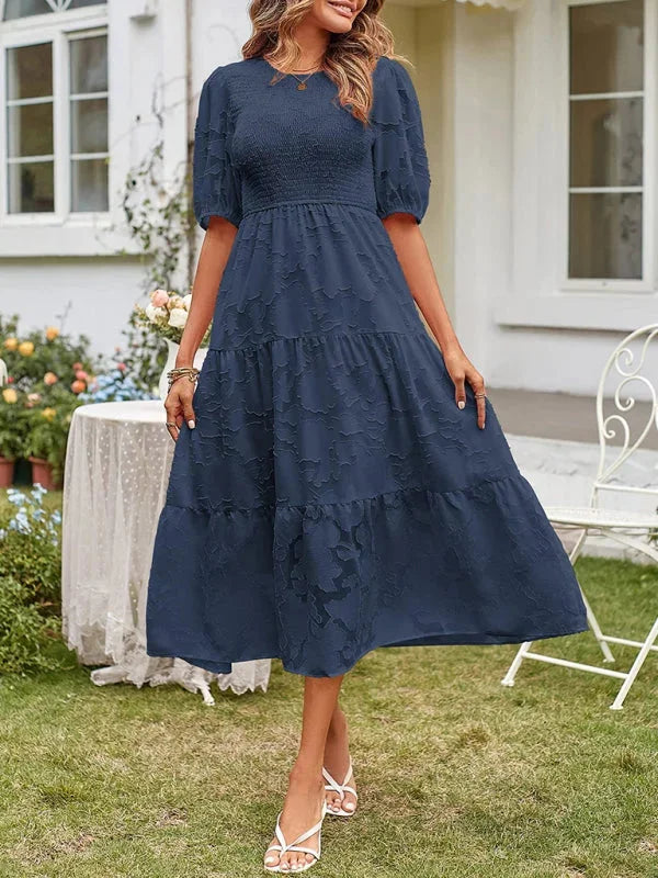 Dark blue floral textured tiered midi dress with a flattering silhouette, perfect for casual outings or special occasions.