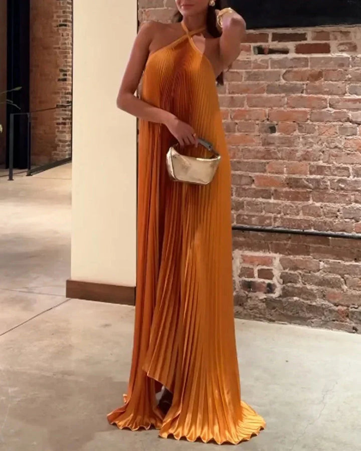 Orange maxi dress with halter neck featuring a flowy silhouette, perfect for a summer day.