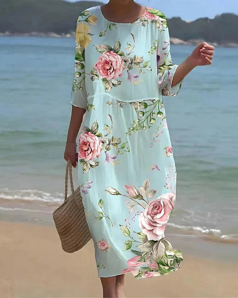 Midi beach dress with sleeves, adorned with floral pattern, perfect for sunny days by the shore.