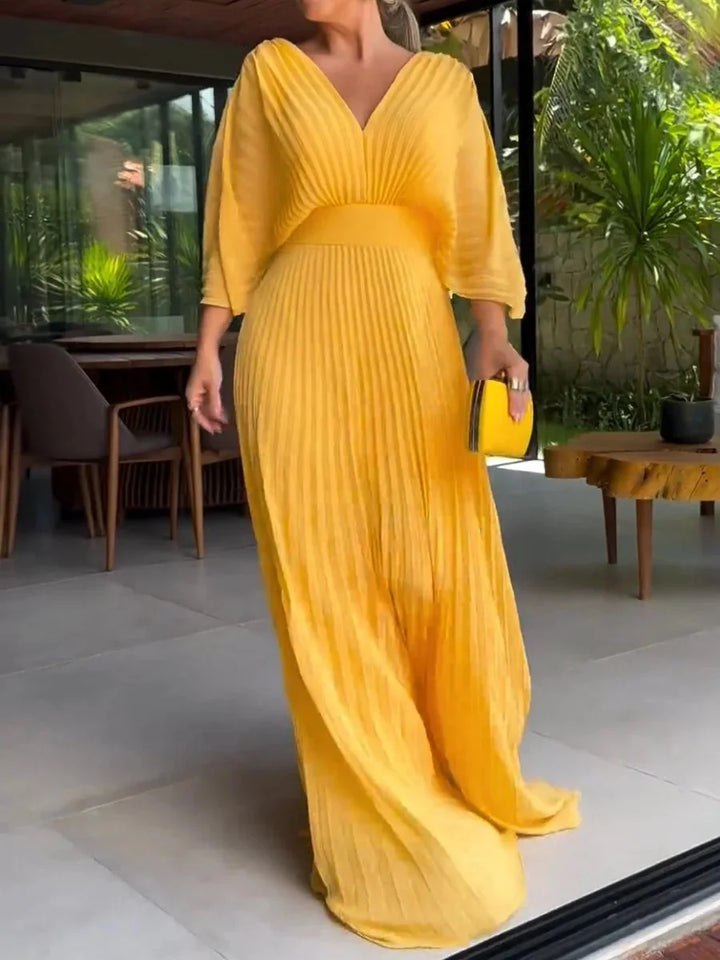 Yellow pleated maxi dress with V-neckline, perfect for sunny days. Flowy and breathable fabric, ideal for a casual chic look.