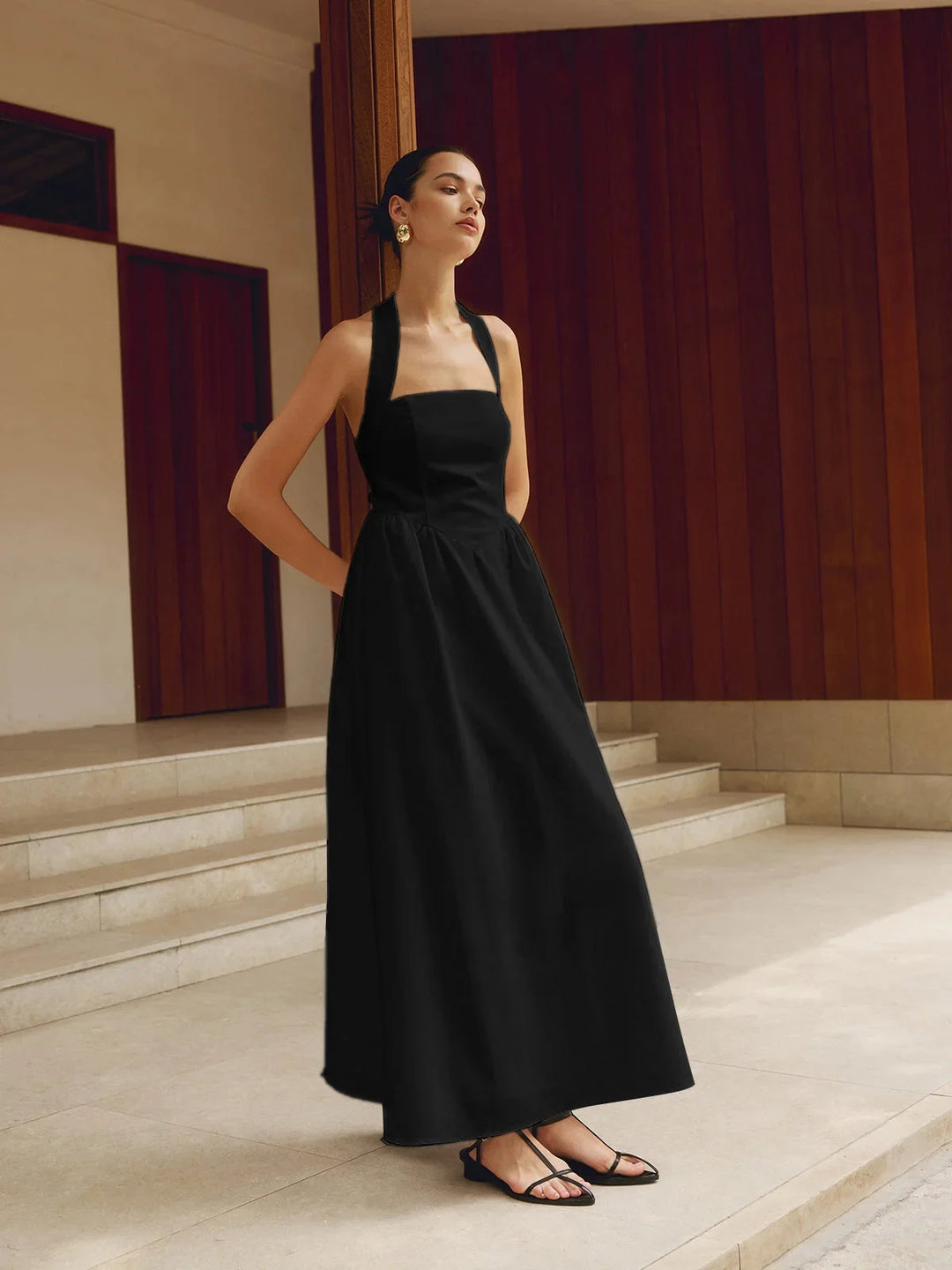 Black sleeveless dress with A-line silhouette. Features a maxi length with a flattering fit. Classic and versatile design in…