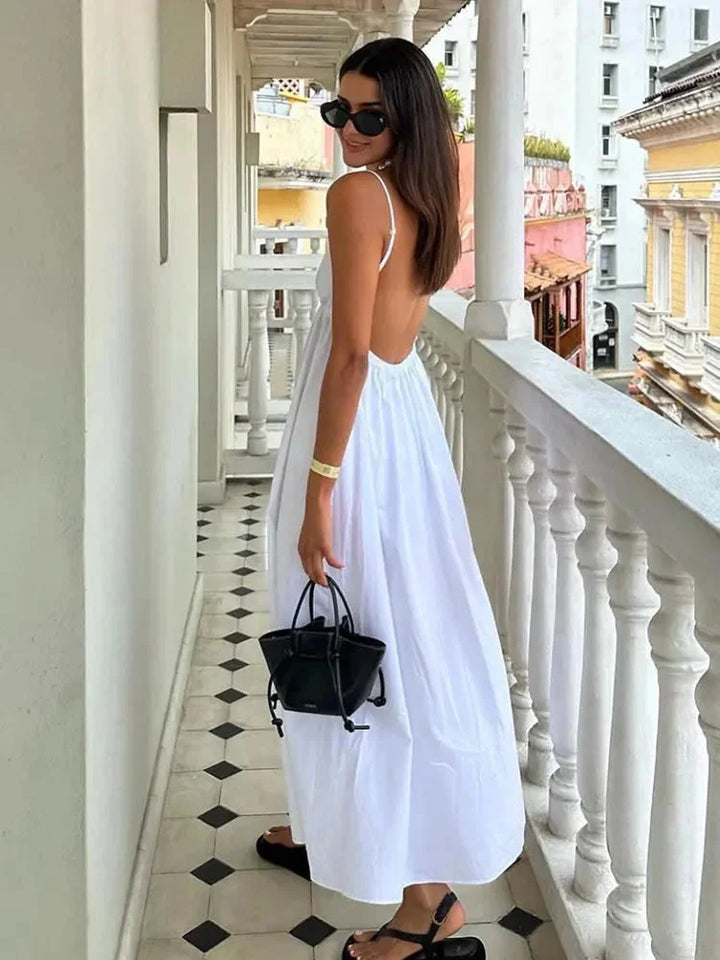 White midi dress with open back and pleated design. Made from high-quality woven fabric. Elegant and chic addition to any…