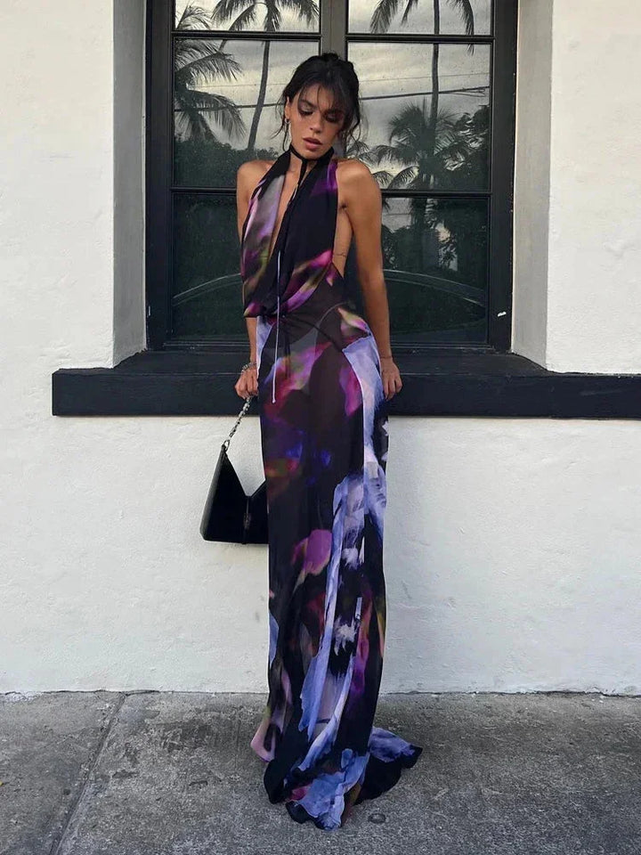 "Purple halter neck maxi dress with abstract print, made of soft, flowy fabric ideal for casual and formal occasions."