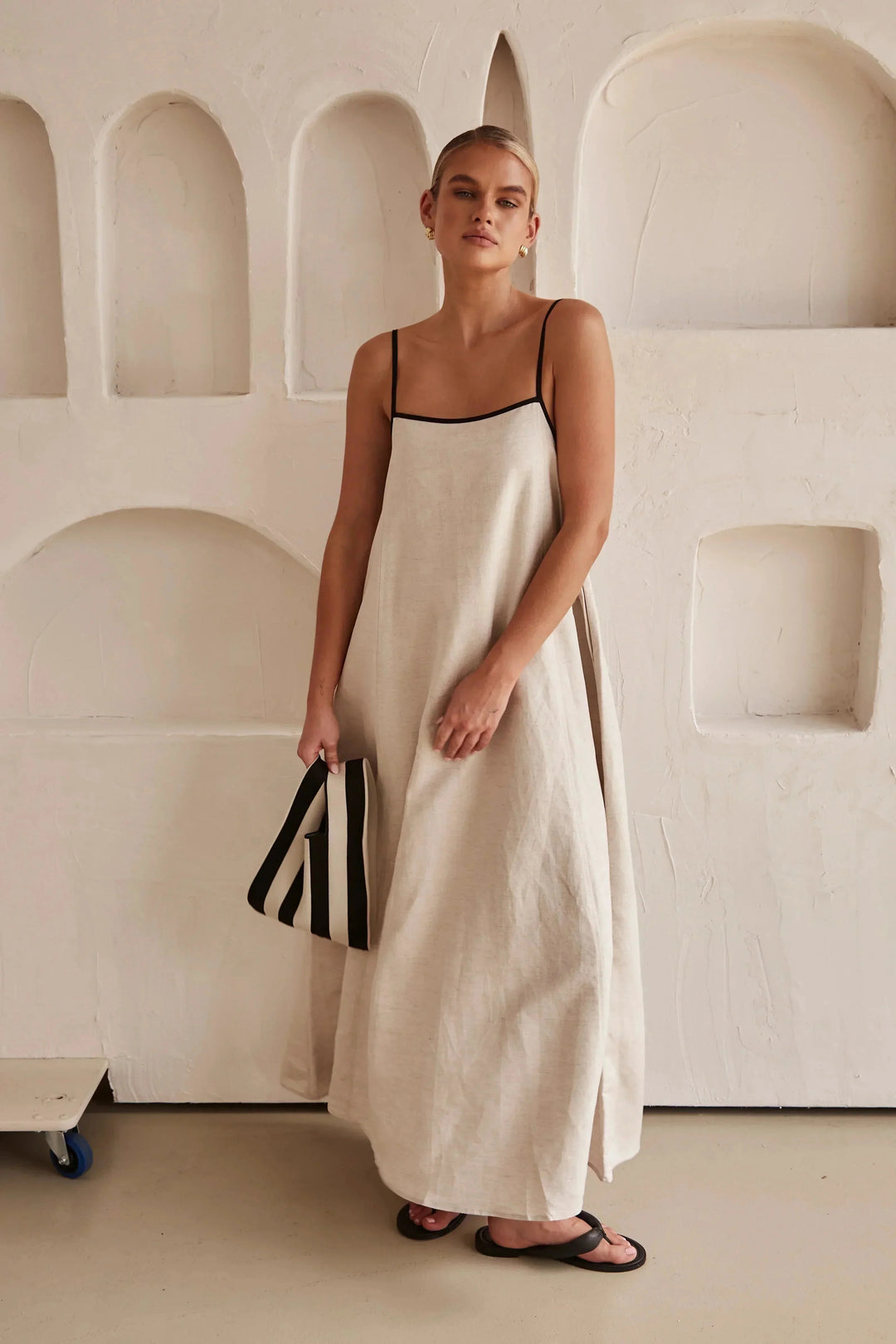 "Beige linen maxi dress featuring black trim accents, perfect for a chic and sophisticated look."