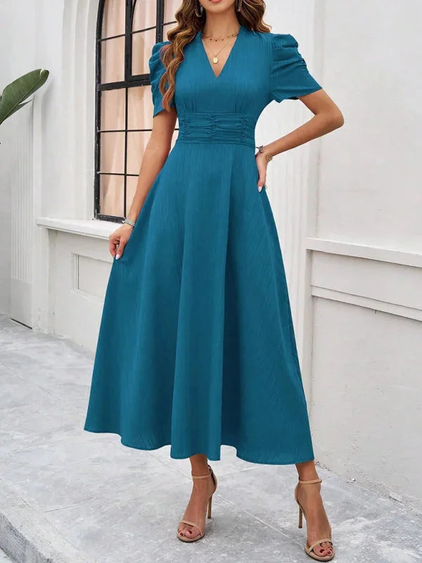 "Blue flowy midi dress with puff sleeves, v-neck, and relaxed fit, perfect for effortless everyday style."