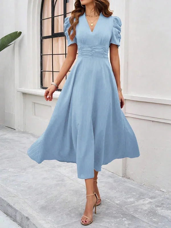 "Flowy midi dress with puff sleeves and V-neck, made from lightweight and breathable fabric."