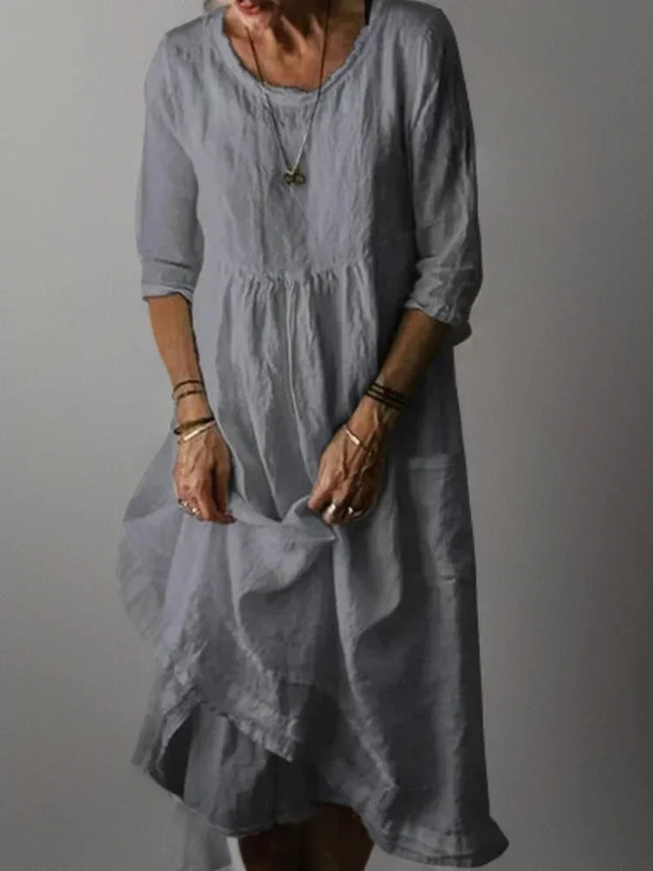 "Grey V-neck tiered maxi dress with 3/4 sleeves, flowy and comfortable design for casual or formal occasions."